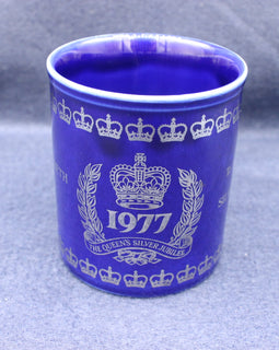 Blue mug with white crown and year design on a gray background