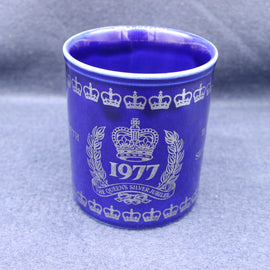 Blue mug with white crown and year design on a gray background