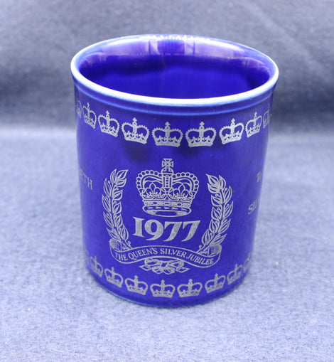 Blue mug with white crown and year design on a gray background