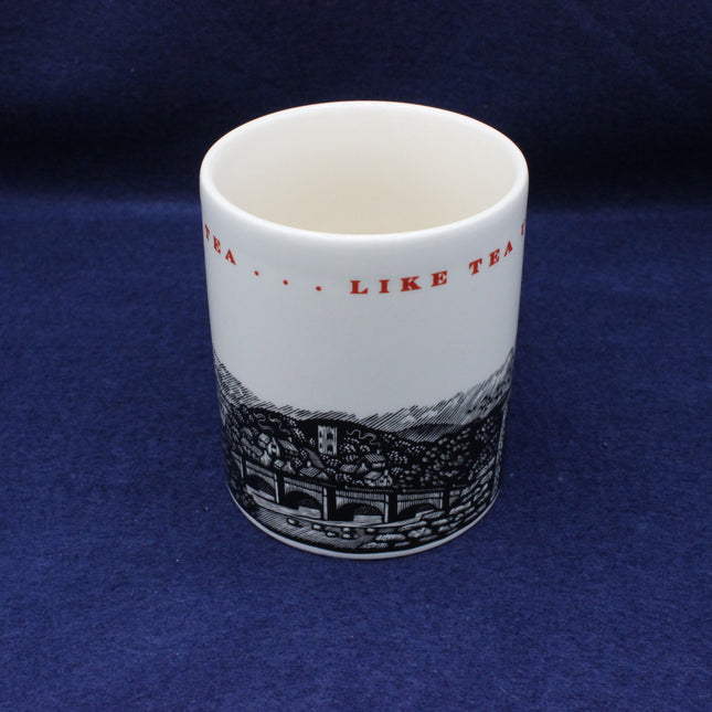 White mug with black and red design on a blue background