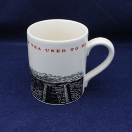 White mug with black and red design on a blue background