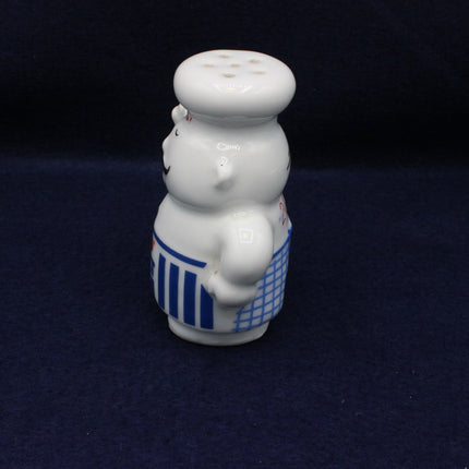 Decorative salt and pepper shaker set shaped like a chef on a dark blue background
