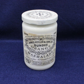 White jar of Dundee Orange Marmalade with a black label on a blue background