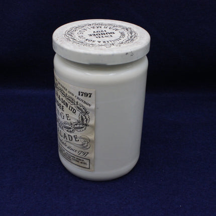 White glass jar with decorative label on a dark blue background
