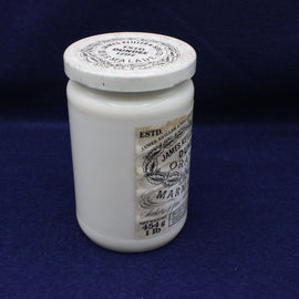 White jar with a decorative label on a blue background