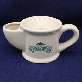 White ceramic tea pot with a handle on a blue background, featuring 'Collins & Wilson' branding.