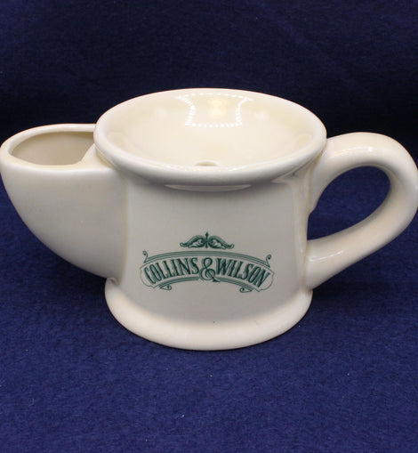 White ceramic tea pot with a handle on a blue background, featuring 'Collins & Wilson' branding.