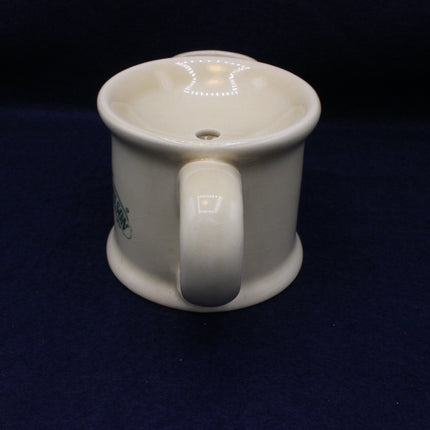 White ceramic tea pot with a handle on a black background