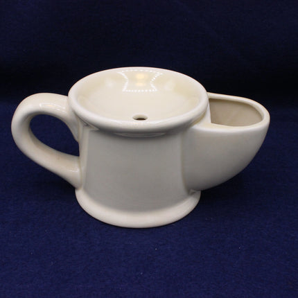White ceramic tea pot with a small bowl on a blue background