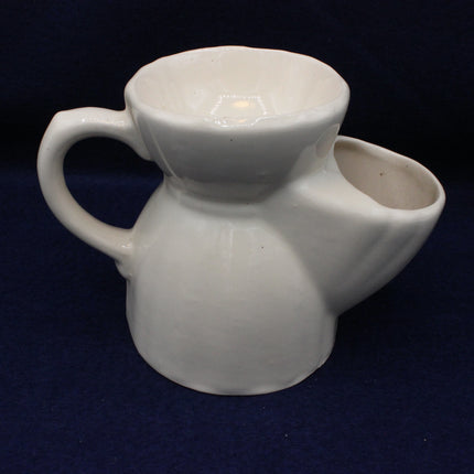White ceramic pitcher on a dark blue background