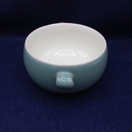 Ceramic bowl with a handle on a dark blue background