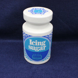 Jar of icing sugar with blue label on a dark blue background