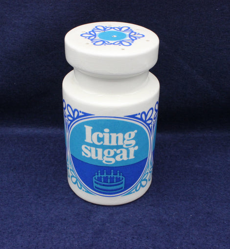 Jar of icing sugar with blue label on a dark blue background