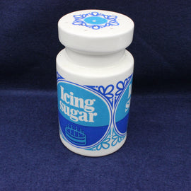Container labeled 'Icing sugar' with blue design on a dark blue background