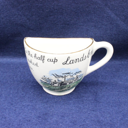 White teacup with scenic Lands End design and text on a blue background