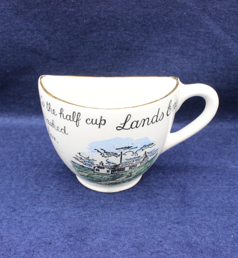 White teacup with scenic Lands End design and text on a blue background