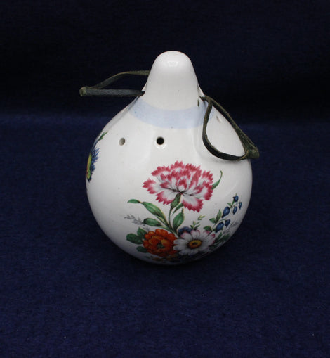 Decorative ceramic scent hanger with floral designs on a dark blue background