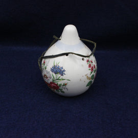 Decorative ceramic object with floral patterns on a dark blue background