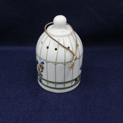 Decorative ceramic birdcage with a small bird on a dark blue background