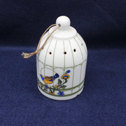 Decorative ceramic bell with floral designs on a blue background