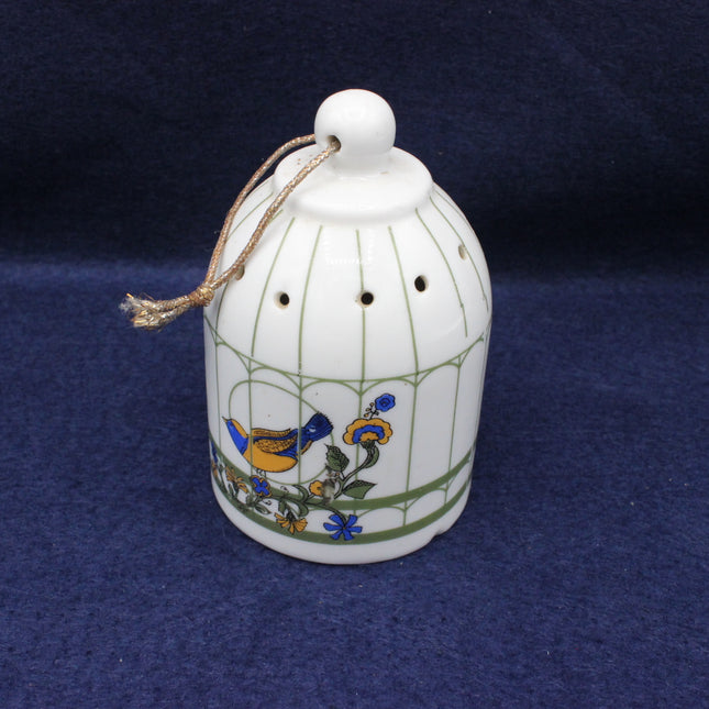 Decorative ceramic bell with floral designs on a blue background