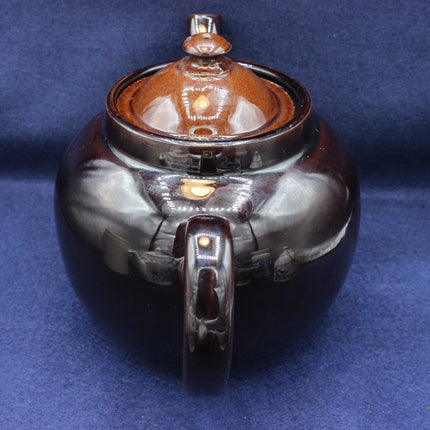Ceramic teapot with a glossy finish on a blue background