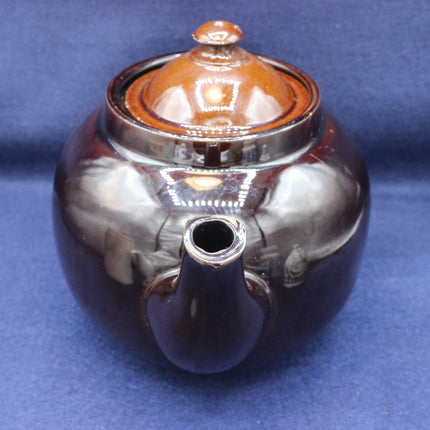 Ceramic teapot with a metallic finish on a blue background