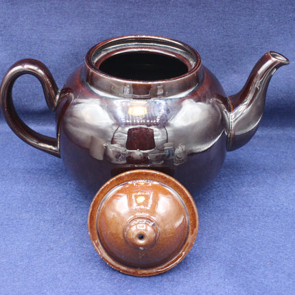 Ceramic teapot with lid on a blue background