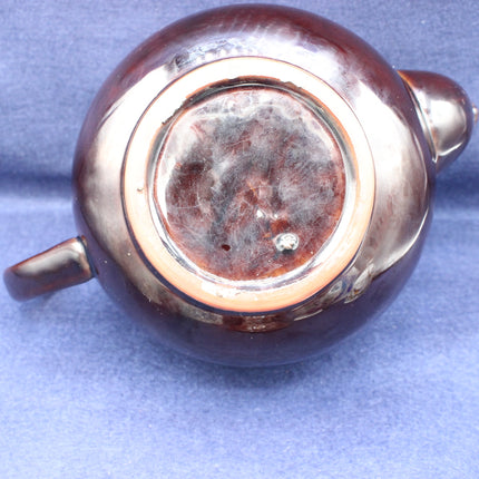 Close-up of a copper teapot base on a blue background