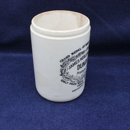 White ceramic cup with black text and design on a blue fabric background