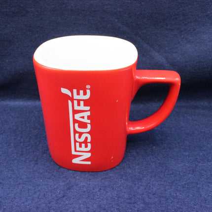 Red Nescafe mug on a blue background