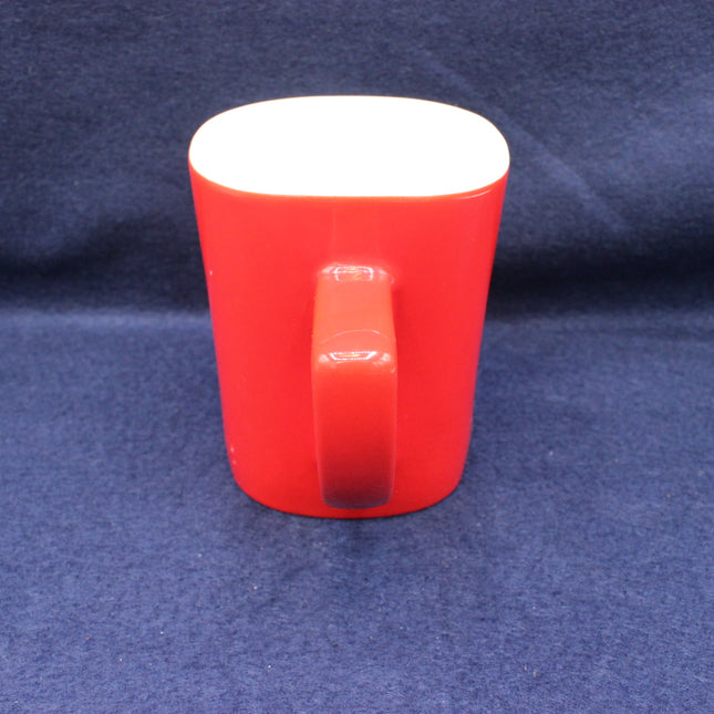 Red mug with a white interior on a blue fabric background