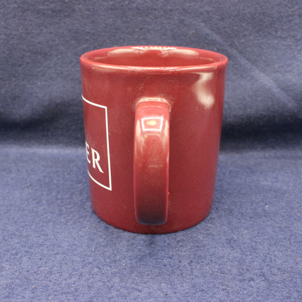 Red mug with a logo on a blue fabric background