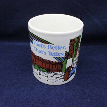 White mug with colorful graphics and text Thats Better Thats Tetley on a blue background