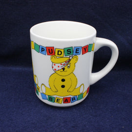 White mug with a colorful design of a bear and text on a dark blue background