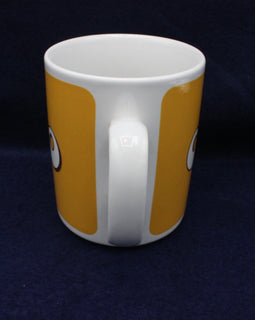 White mug with orange stripes on a dark blue background