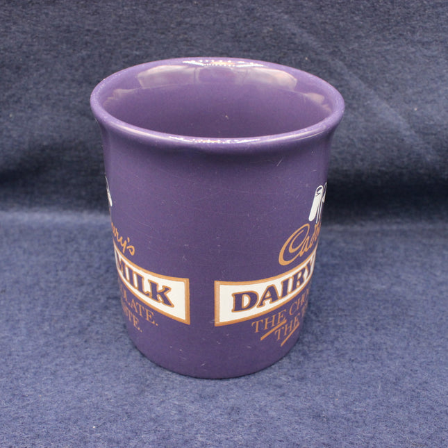 Purple cup with Cadbury Dairy Milk branding on a dark blue background