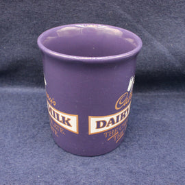 Purple cup with Cadbury Dairy Milk branding on a dark blue background