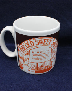 White mug with orange and brown design on a blue background