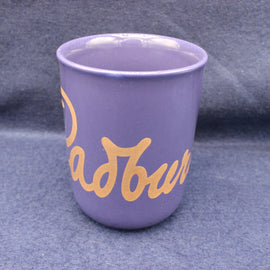 Purple mug with gold text on a grey background