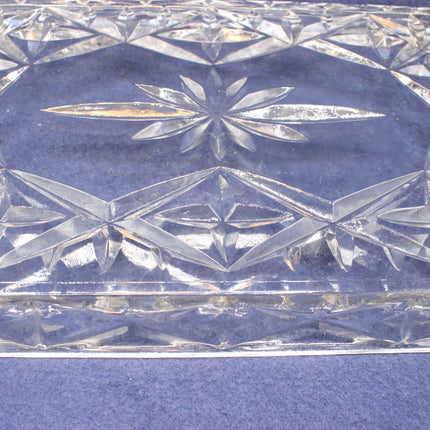 Close-up of a crystal dish with geometric patterns on a blue background