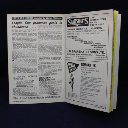 Open book with sports-related text and advertisements on a dark background