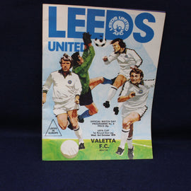 Vintage Leeds United football program with player illustrations on a dark background