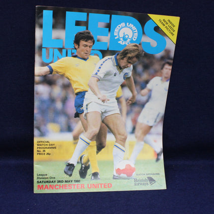 Vintage football match programme for Leeds United vs Manchester United featuring action shots of players.