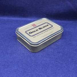 Gold Block tobacco tin on a blue fabric background