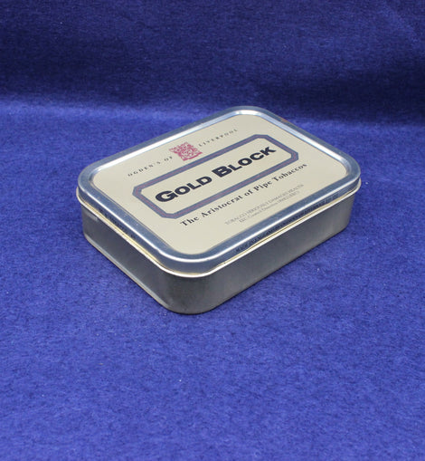 Gold Block tobacco tin on a blue fabric background