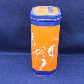 Hexagonal tin can with orange and blue design on a blue background