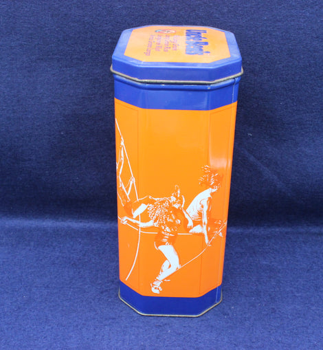 Hexagonal tin can with orange and blue design on a blue background