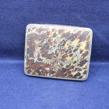 Vintage tortoiseshell case with decorative design on a blue background