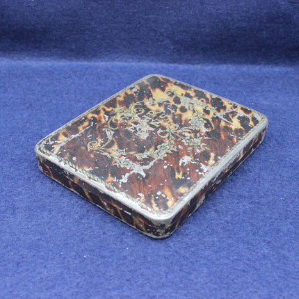 Tortoiseshell case with intricate patterns on a blue background